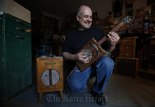 Guitar builder Matthew (Matty) Baratto with one of his custom Cigfiddle cigar-box guitars and his handmade amp inside his North Holllywood shop.  MCT