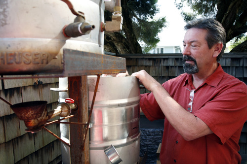 Mark Taylor explains the mechanics of his backyard gravity-fueled
beer sculpture at his Capitola, California home.
Santa Cruz Sentinel/MCT