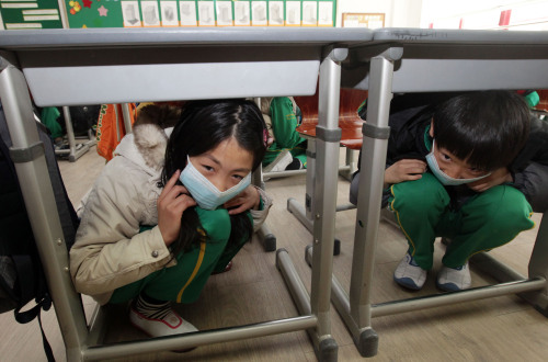 Elementary school children are hiding underneath the desk during a nationwide civil defense training. (Yonhap News)