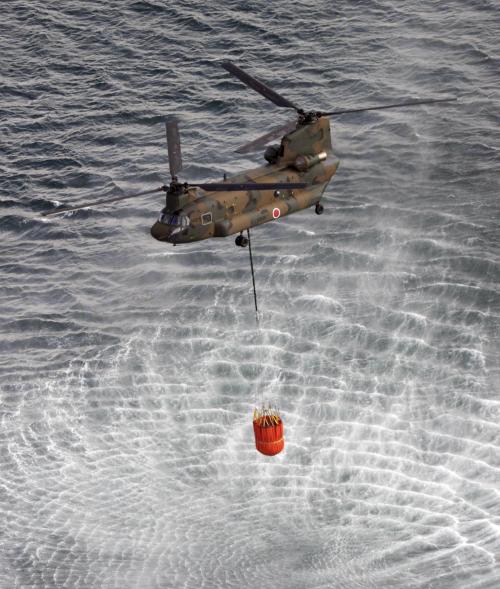 <YONHAP PHOTO-1011> Japan's Self-Defense Forces's helicopter scoops water off Japan's northeast coast on its way to the Fukushima Dai-ichi nuclear power plant in Okumamachi Thursday morning, March 17, 2011. Helicopters are dumping water on a stricken reactor in northeastern Japan to cool overheated fuel rods inside the core. (AP Photo/Yomiuri Shimbun, Kenji Shimizu) JAPAN OUT, MANDATORY CREDIT/2011-03-17 10:33:22/ <저작권자 ⓒ 1980-2011 ㈜연합뉴스. 무단 전재 재배포 금지.>
A Japan Self-Defense Forces helicopter scoops water off Japan’s northeast coast on its way to the Fukushima Daiichi nuclear power plant in Okumamachi on Thursday.      AP-Yonhap News