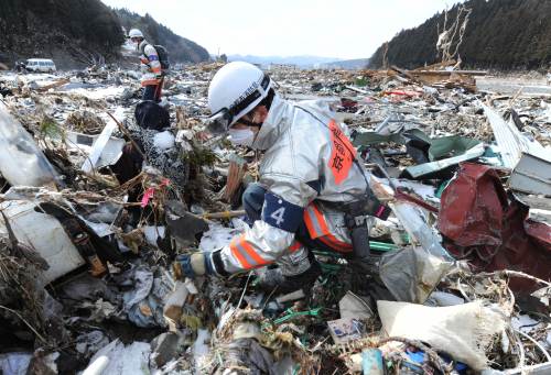 Rescue workers search through debris in Minamisanriku, Miyagi prefecture on Friday. AFP-Yonhap News
