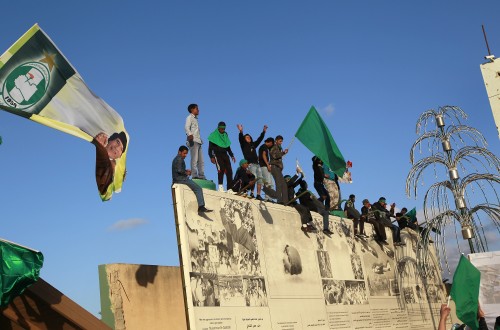 Supporters of Libyan leader Moammar Gadhafi wave flags as they anticipate his arrival at his Bab Al Azizia compound in Tripoli, Libya, Saturday. (AP-Yonhap News)