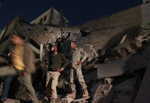 soldiers survey the damage to an administrative building hit by a missile late Sunday in the heart of Moammar Gadhafi's Bab Al Azizia compound in Tripoli, Libya. (AP-Yonhap News)