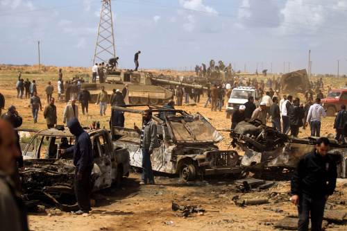 <YONHAP PHOTO-0703> Libyan onlookers gather at the site where forces of Moamer Kadhafi were targeted the day before by a French air strike in Al-Wayfiyah, 35 kms West of Benghazi, on March 21, 2011 as news reports said Libyan government forces pulled back 100 kilometres (60 miles) from rebel-held Benghazi but showed they still had plenty of fight as they beat off an insurgent advance. AFP PHOTO/PATRICK BAZ /2011-03-22 08:06:43/ <저작권자 ⓒ 1980-2011 ㈜연합뉴스. 무단 전재 재배포 금지.>
Libyan onlookers gather at the site where forces of Moammar Gadhafi were targeted the day before by a French air strike in Al-Wayfiyah, 35 kilometers west of Benghazi, Monday.   AFP-Yonhap News