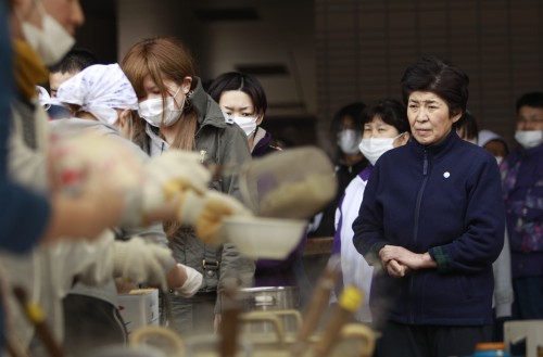 <YONHAP PHOTO-2409> A woman waits for a bowl of soup at an evacuee center for leaked radiation from the damaged Fukushima nuclear facilities, Tuesday, March 22, 2011 in Fukushima, Fukushima Prefecture, Japan. Before the disasters, safety drills were seldom if ever practiced and information about radiation exposure rarely given in Futuba, a small town in the shadow of the nuclear plant in Fukushima Prefecture. (AP Photo/Wally Santana)/2011-03-22 19:28:41/ <저작권자 ⓒ 1980-2011 ㈜연합뉴스. 무단 전재 재배포 금지.>
A woman waits for a bowl of soup at an evacuee center Tuesday, in Fukushima, Japan.  AP-Yonhap News