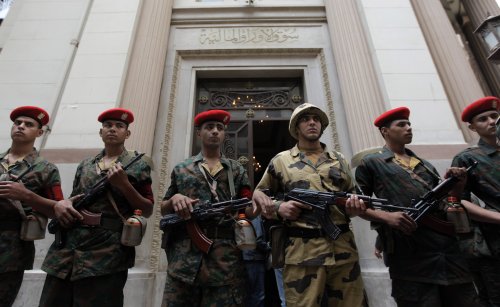 Egyptian army soldiers guard the entrance of Egypt's stock exchange, background, during it's reopening session after a nearly two-month closure, in Cairo. (AP-Yonhap News)