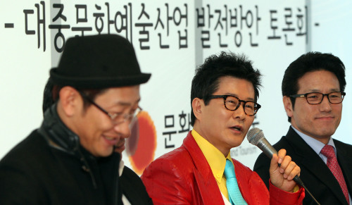 <YONHAP PHOTO-1040> 태진아 대한가수협회회장 (서울=연합뉴스) 김연정 기자 = 25일 오전 서울 강남구 청담동 SM엔터테인먼트 사옥에서 열린 대중문화예술산업 발전방안 토론회에서 태진아 대한가수협회회장(가운데)이 의견을 제시하고 있다. 정병국 문화체육관광부 장관, 주요 연예기획사, 대중문화 관련 협ㆍ단체, 학계ㆍ언론계 등 20여명이 참석해 연예산업 환경과 제도개선 방안에 대해 토론하고 있다. 2011.3.25 maum@yna.co.kr/2011-03-25 13:07:50/ <저작권자 ⓒ 1980-2011 ㈜연합뉴스. 무단 전재 재배포 금지.>
Tae Jin-ah (center), president of the Korean Singers Association and Choung Byoung-gug (right), Minister of Culture, Sports and Tourism, participate in a forum to discuss ways to improve the nation’s entertainment business at SM Entertainment’s office in Seoul on Friday.  Yonhap News