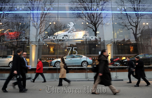 Pedestrians pass the PSA Peugeot Citroen company headquarters in Paris.  Bloomberg