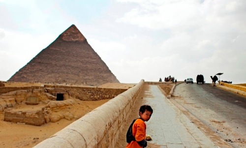Young souvenir vendor walks along an almost empty road to the Giza pyramids on the outskirts of Cairo, Egypt. (AP-Yonhap News)
