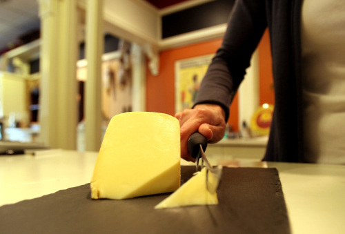 Erika Aylward, co-owner of Boulevard Market, cuts a piece of raw
milk gouda cheese at her store in Tecumseh, Michigan, March 17.
(Detroit Free Press/MCT)