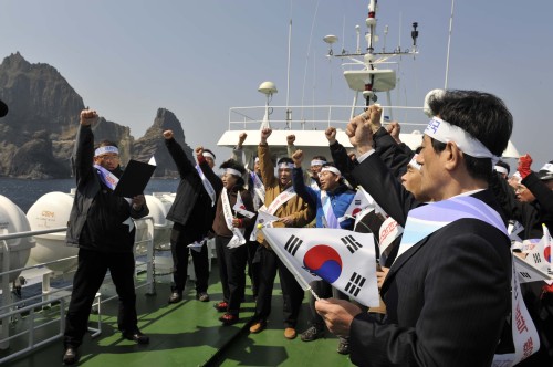 <YONHAP PHOTO-1708> "일본 독도영유권 침탈 규탄한다" (대구=연합뉴스) 홍창진 기자 = 경북도교육청은 30일 독도 해역 평화호 선상에서 23개 지역교육청 교육장협의회를 열고 일본 중학교 사회교과서의 독도 영유권 침탈 및 역사 왜곡 규탄대회를 개최했다. 이영우 교육감(사진 오른쪽)과 지역교육장들이 영토주권을 지키는 교육활동에 힘쓸 것을 결의하고 있다. 2011.3.30 realism@yna.co.kr/2011-03-30 17:22:14/ <저작권자 ⓒ 1980-2011 ㈜연합뉴스. 무단 전재 재배포 금지.>
Education officials from North Gyeongsang Province denounce Japanese textbooks’ territorial claims over Dokdo aboard a ship near the rocky islets in the East Sea last week.   Yonhap News