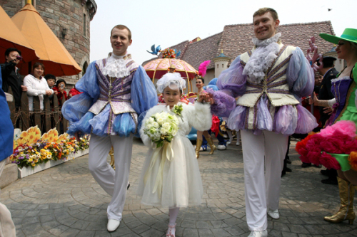 The bride Zhu Jie walks to the wedding ceremony accompanied by two attendants at their wedding. (Xinhua News)
