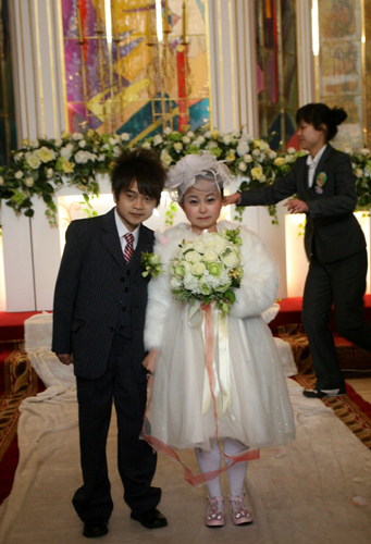The bride Zhu Jie poses for a photo with her groom Qin Xueshi at their wedding. (Xinhua News)