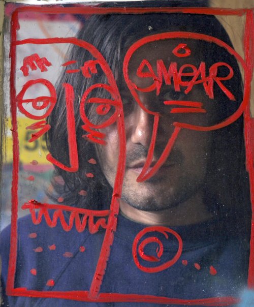<YONHAP PHOTO-0489> In this photo taken on Monday, March 28, 2011, artist Cristian Gheorghiu is seen behind a "Smear" character painted on a window frame at his East Hollywood garage studio in Los Angeles. Gheorghiu, known by his nickname of "Smear," faces an injunction that could bar him from profiting from art bearing his telltale graffiti "tag." But Gheorghiu's lawyer says the city attorney's lawsuit is a thinly-veiled attempt around the First Amendment right to free expression. (AP Photo/Damian Dovarganes)/2011-04-03 06:02:49/ <저작권자 ⓒ 1980-2011 ㈜연합뉴스. 무단 전재 재배포 금지.>
Artist Cristian Gheorghiu is seen behind a “Smear” character painted on a window frame at his East Hollywood garage studio in Los Angeles.  AP-Yonhap News