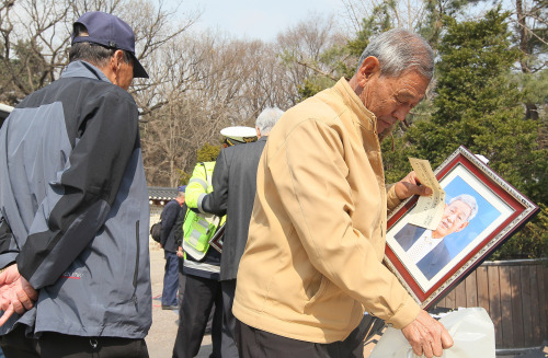 <YONHAP PHOTO-0283> 서울 노인 인구 100만명 첫 돌파 (서울=연합뉴스) 박지호 기자 = 6일 서울시에 따르면 지난해 12월31일 현재 서울에 사는 만65세 이상 고령인구가 처음으로 100만명을 넘어선 것으로 나타났다. 사진은 지난 4일 오후 서울 종묘공원에서 노인들이 혜화경찰서와 한국사진기자협회가 무료로 촬영해준 영정사진을 받아가는 모습. 2011.4.6 jihopark@yna.co.kr/2011-04-06 06:48:19/ <저작권자 ⓒ 1980-2011 ㈜연합뉴스. 무단 전재 재배포 금지.>
Senior citizens receive their portrait taken for free at a park in Seoul.  Yonhap News