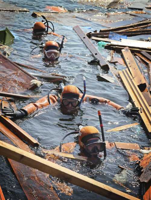 <YONHAP PHOTO-2677> In this Tuesday, April 5, 2011 photo, scuba divers form a line as they search for the bodies of missing people in water of Yoriiso fishing port in Ishinomaki, Miyagi Prefecture following the March 11 earthquake and tsunami hit northeastern Japan. (AP Photo/Yomiuri Shimbun, Naoki Maeda) JAPAN OUT, MANDATORY CREDIT/2011-04-06 21:30:43/ <저작권자 ⓒ 1980-2011 ㈜연합뉴스. 무단 전재 재배포 금지.>
일본 미야기 현 이시노마키 요리이소항에서 5일 스쿠버다이버가 실종된 사람의 시신을 찾고 있다.
［이시노마키=AP연합뉴스］