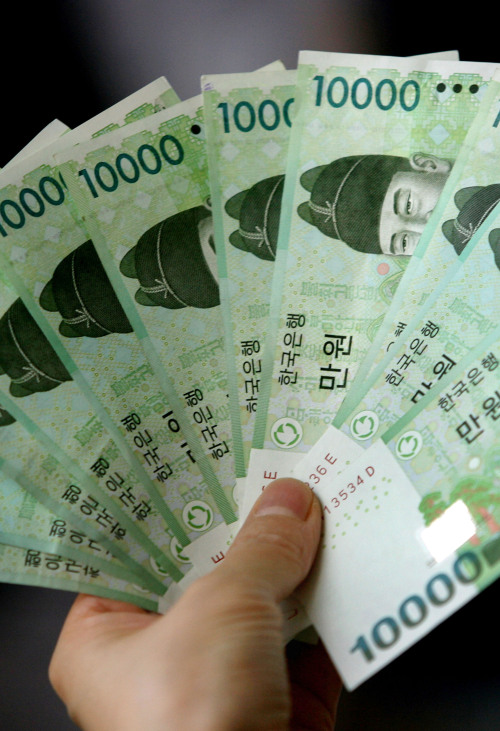 South Korean won bills are displayed for a photograph in Seoul, South Korea, on Sunday, Sept. 9, 2007.  South Korean tourists, companies and investors are spending record amounts overseas, jeopardizing the won's three-year run as Asia's best-performing currency. Photographer: Nasha Lee/Bloomberg News.