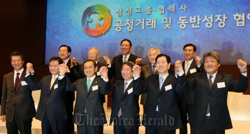 13일 서울 서초구 서초동 삼성전자 사옥에서 '삼성그룹, 공정거래 및 동반성장 협약식'이 열려 정운찬 동반성장위원장, 김동수 공정거래위원장, 김순택 삼성 미래전략실장, 손경식 대한상의 회장 및 협력사 대표들이 손을 맞잡고 있다.<br />김명섭 기자 msiron@
Samsung Electronics CEO Choi Gee-sung (second from right), head of the Commission on Shared Growth for Large and Small Companies Chung Un-chan (third from right), Fair Trade Commission Chairman Kim Dong-soo (third from left) and Kim Soon-taek, a Samsung Electronics vice chairman and head of the group’s planning department (second from left) at an event declaring the group’s commitment to fair trade and shared growth at Samsung Electronics’ office in Seoul on Wednesday. Kim Myung-sub/The Korea Herald