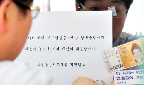 14일 오전 농협 전산장애 사태가 대부분 복구 되고 카드입출금 거래만 장애중인 가운데 서울 강남구 농협 봉은사로 지점에서 직원이 안내문을 붙이고 있다.<br alt=