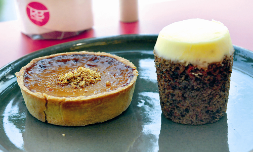 Rose Bakery’s single-serving-sized carrot cake (right) hews to the wholesome yet no-holds-barred aesthetic of the quaint Seoul shop with its decadent cream cheese frosting and organic vibe, garnering more popularity than the brand’s toothsome caramel tart (left).