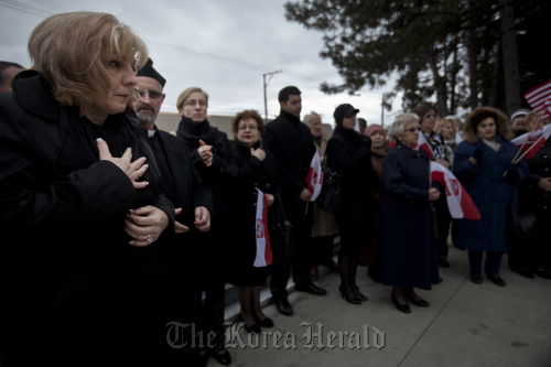 Anna Wojtowicz (left), daughter of Wojciech Seweryn who died in plane crash a year ago, at a prayer service at the monument to victims of the Katyn massacre at St. Adalbert’s Cemetery in Niles, Illinois on April 4.  Chicago Tribune/MCT
