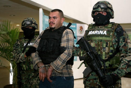 Members of the Navy escort Martin Omar Estrada Luna, center, alias "El Kilo," during a presentation to the press in Mexico City, Sunday, April 17, 2011. The Mexican Navy said Saturday it had captured Estrada Luna, the presumed leader of the San Fernando cell of the Zetas drug gang, suspected in the case of the mass graves found in Tamaulipas, as well as the migrant massacre last August in the violent border state across from Texas. (AP-Yonhap News)