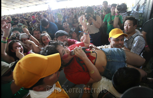 Lovefoxxx, lead singer of CSS, is helped back on stage after surfing the crowd at the Coachella Valley Music and Arts Festival at the Empire Polo Grounds in Indio, California, Sunday.  MCT