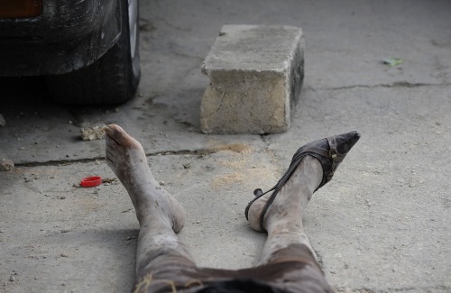 In this Jan. 2010 photo submitted by the Washington Post tilted "The Moment Time Stopped," survivors piled bodies of the dead outside for weeks after earthquake in Port-au-Prince. (AP-Yonhap News)