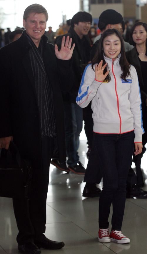 <YONHAP PHOTO-0791> 연아손짓 (영종도=연합뉴스) 한상균 기자 = 2011 국제빙상경기연맹(ISU) 세계선수권대회에 출전하는 김연아가 22일 피터 오피가드 코치와 인천공항을 통해 출국하고 있다. 이번 대회는 러시아 모스크바에서 열린다. 2011.4.22 xyz@yna.co.kr/2011-04-22 12:13:00/ <저작권자 ⓒ 1980-2011 ㈜연합뉴스. 무단 전재 재배포 금지.>
Figure skating champion Kim Yu-na and her American coach Peter Oppegard wave to the crowd at Incheon International Airport on Friday.   Yonhap News