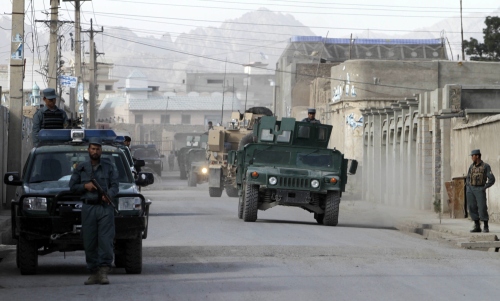 Afghan and NATO forces secure the entrance of the police headquarters after a Taliban suicide attack killed the police chief of southern Afghanistan's Kandahar province, Khan Mohammad Mujahid and his two bodyguards, in Kandahar, Afghanistan, Friday April 15, 2011. (AP-Yonhap News)