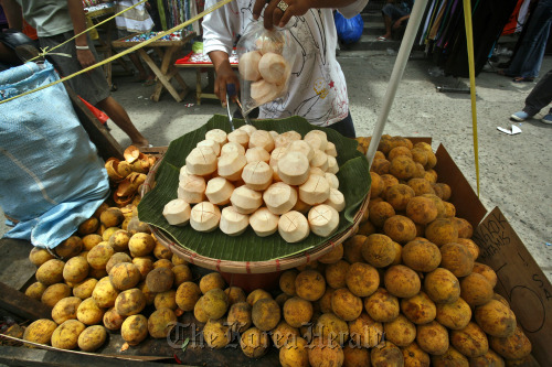 A fruit vendor sells coconuts in Manila. Bloomberg