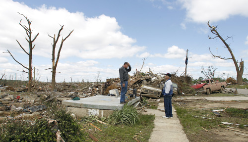 Billy Burns stands on his front porch talking to a neighbor after a tornado hit Pleasant Grove just west of downtown Birmingham yesterday afternoon on Thursday, April 28, 2011, in Birmingham, Ala.  (AP-Yonhap News)