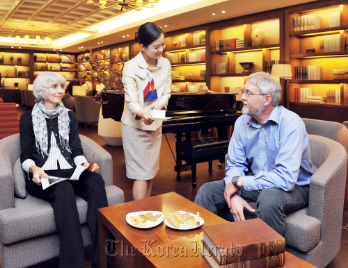 People receive service from an Asiana Airlines’ employee at the company lounge located at the Incheon International Airport on Sunday. Asiana Airlines