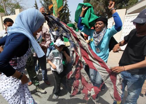 <YONHAP PHOTO-0102> THIS PICTURE WAS TAKEN ON A GUIDED GOVERNMENT TOUR Supporters of Libyan leader Moamer Kadhafi burn a US flag as they protest outside a house which was hit by a NATO air strike overnight in the Gargur area of Tripoli on May 1, 2011 as the Libyan regime said the raid killed Kadhafi's youngest son and three grandchildren but that the strongman escaped unhurt in what it called a deliberate attempt to assassinate him. AFP PHOTO/MAHMUD TURKIA /2011-05-02 00:33:11/ <저작권자 ⓒ 1980-2011 ㈜연합뉴스. 무단 전재 재배포 금지.>
Supporters of Libyan leader Moammar Gadhafi burn a U.S. flag as they protest outside a house that was hit by a NATO air strike overnight in the Gargur area of Tripoli on Saturday.  AFP-Yonhap News