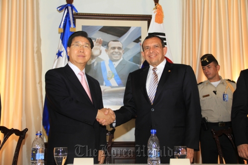POSCO chief executive Chung Joon-yang (left) and Honduras President Porfirio Lobo Sosa shake hands after signing an MOU on the country’s infrastructure in Honduras on Wednesday.  POSCO