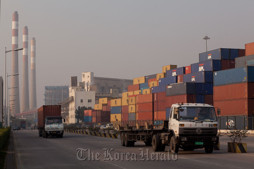 Truckers drive past stacks of transport containers at Chiwan Container Terminals, Port of Shekou in Shenzhen, Guangdong province, China.  Bloomberg