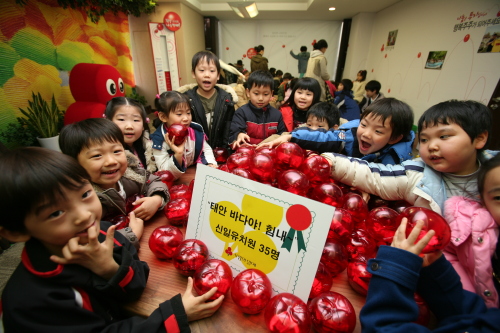 Children at Shinil Kindergarten in Seoul show piggy banks full of cash after raising funds for Community Chest of Korea causes.