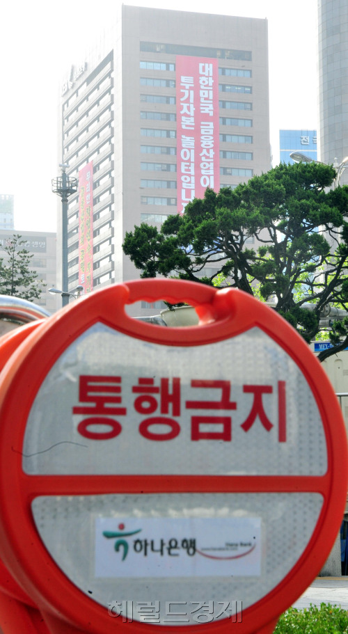 금융당국이 하나금융지주의 외환은행 인수안 처리를 연기한 가운데 13일 서울 을지로 하나은행 본점에서 바라본 외환은행 본점에 인수 반대 현수막이 걸려 있다.<br />김명섭 기자 msiron@
멀리 외환은행 빌딩에  외환은행 인수  반대 현수막이 걸린 가운데  외환은행 인수가 사실상 좌절된 13일 오전 하나은행 본점앞 통행금지 표지판이 의미심장하다.
김명섭 기자/msiron@heraldm.com
멀리 외환은행 빌딩에  외환은행 인수  반대 현수막이 걸린 가운데  외환은행 인수가 사실상 좌절된 13일 오전 하나은행 본점앞 통행금지 표지판이 의미심장하다.
김명섭 기자/msiron@heraldm.com