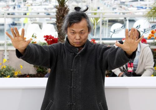 <YONHAP PHOTO-2568> South Korean director and actor Kim Ki-Duk gestures during a photocall for the film "Arirang" in competition for the category "Un Certain Regard" at the 64th Cannes Film Festival May 13, 2011. REUTERS/Yves Herman (FRANCE - Tags: ENTERTAINMENT)/2011-05-13 19:50:41/ <저작권자 ⓒ 1980-2011 ㈜연합뉴스. 무단 전재 재배포 금지.>
Kim Ki-duk demonstrates martial art-like movements at Cannes Film Festival on Friday.  AFP-Yonhap News