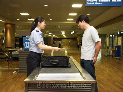 A Korea Customs Service worker inspects a traveller’s bag at Incheon International Airport. KCS