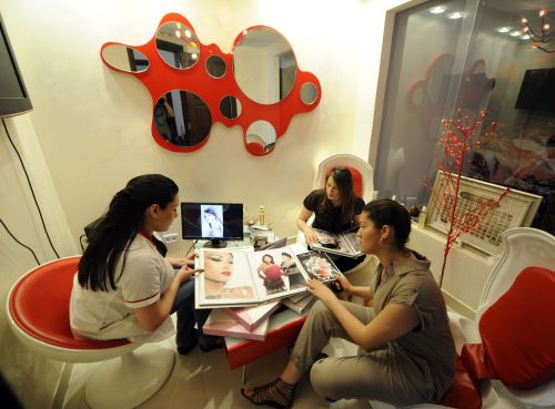 <YONHAP PHOTO-1456> TO GO WITH AFP STORY "Tunisia-politics-unrest-women-lifestyle,SCENE" BY SONIA BAKARIC Young women flip through catalogues to choose hairstyles they like in a hairdressing salon called "Boulbaba", one of the most famous in Tunis, on May 13, 2011. Because of the city's nightly curfew, trips to hair salons and spas for regularly beauty treatments must be hurried or cut short to ensure women get home in good time. AFP PHOTO / FETHI BELAID /2011-05-16 12:25:31/ <저작권자 ⓒ 1980-2011 ㈜연합뉴스. 무단 전재 재배포 금지.>
Young women choose hairstyles in a hairdressing salon called “Boulbaba,” one of the most famous in Tunis, on May 13.  AFP-Yonhap News