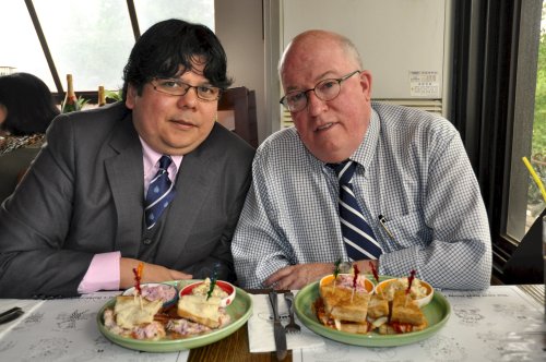 Patrick Linehan (right) and Emerson Kanegusuke posing with a sandwich named after them at an Itaewon restaurant. (Yoav Cerralbo/The Korea Herald)