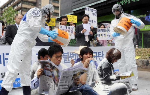 녹색연합, 주한미군범죄근절운동본부, 민주사회를위한변호사모임 등 시민단체는 23일 오전 광화문 미 대사관 옆에서 ‘캠프 캐럴 미군기지 고엽제 불법매립 규탄 기자회견’을 가진 뒤 신문을 읽는 등 일상생활을 하는 시민들 위로 흰 가루를 뿌리는 퍼포먼스를 진행했다.  박해묵 기자/mook@