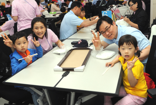 신한생명은 5월 가정의 달을 맞아 천안 소재 연수원에서 임직원과 가족이 함께 즐거운 시간을 보낼 수 있는 ‘엄마 아빠네 회사로 소풍가요’ 행사를 진행했다고 24일 밝혔다. 이 회사는 즐겁고 일할 맛 나는 기업문화를 만들기 위한 일환으로, 미취학 자녀를 둔 직원가족 200여 명을 초청해 가족의 꿈을 담은 나무만들기 등 다양한 행사를 벌였다. 한 직원 가족이 단란한 시간을 보내며 기념사진을 찍고 있다.
