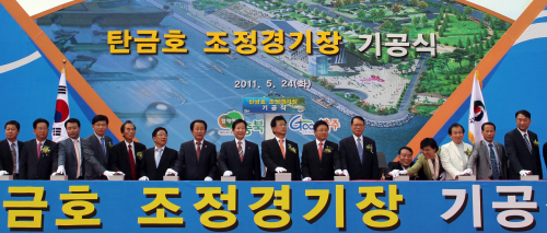<YONHAP PHOTO-1349> 2013충주세계조정 경기장 첫삽 (충주=연합뉴스) 노승혁 기자 = 2013충주세계조정선수권대회가 열릴 충북 충주시 탄금호 국제조정경기장 기공식이 24일 가금면 탑평리 조정경기장 조성구역 내에서 열렸다. 2011.5.24 nsh@yna.co.kr/2011-05-24 15:36:23/ <저작권자 ⓒ 1980-2011 ㈜연합뉴스. 무단 전재 재배포 금지.>
The groundbreaking ceremony is held in Chungju.  Yonhap News