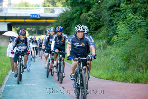 LS Cable and System chairman and chief executive Koo Cha-yol (front) rides with the company’s cycling club members in Anyang, Gyeonggi Province in 2008. LS Cable and System