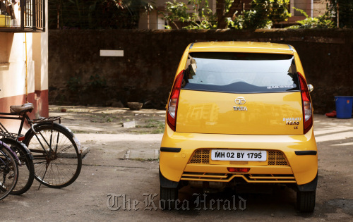 A Tata Motors Ltd. Nano automobile parked in front of a building in Mumbai, India.   Bloomberg