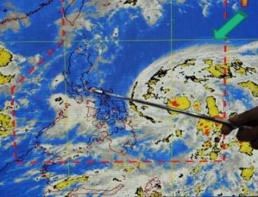 A Philippine weather forecaster points to a satellite image showing the position of Tropical storm Songda during a media briefing last week. (AFP-Yonhap News)