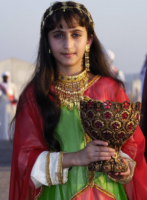 By Yoav Cerralbo
An Omani girl in a traditional dress holds
an original Omani vase. Oman Embassy
