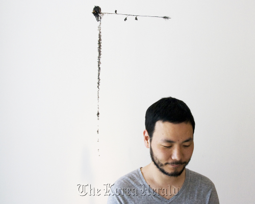 Ham Jin stands under one of his works at PKM Gallery in Hwa-dong, central Seoul.  PKM Gallery